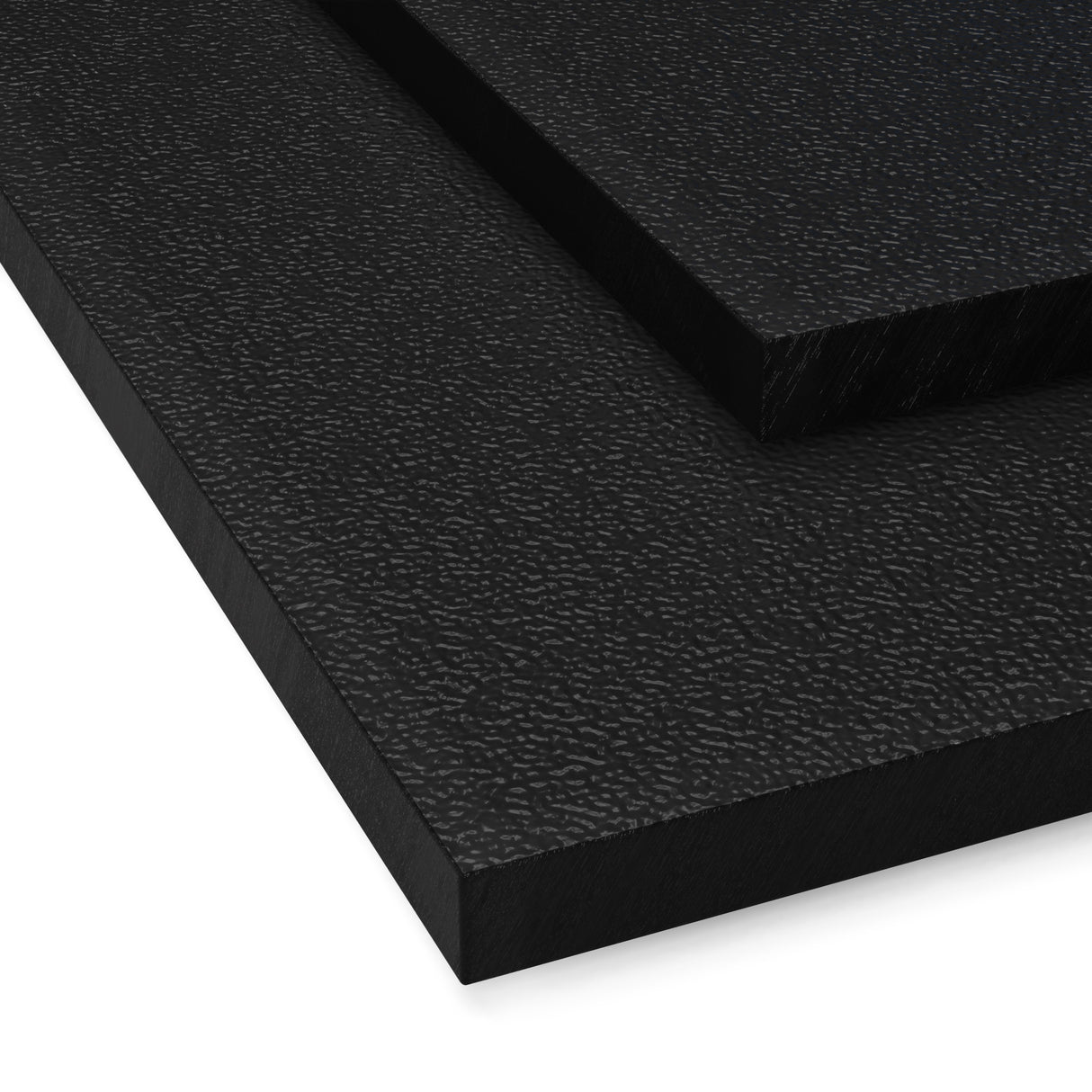 Czarna płyta z tworzywa ABS o drobnym moletowaniu z wyraźnie widoczną chropowatą strukturą powierzchni płyty ułożone warstwowo pokazujące różne grubości i fakturę materiału