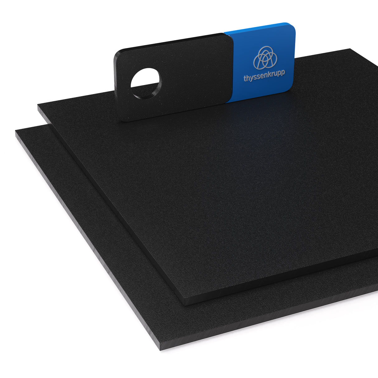 Czarna płyta z tworzywa ABS z drobnym moletowaniem o matowej i lekko chropowatej powierzchni ułożona w dwóch warstwach na górnej płycie znajduje się próbnik z logo thyssenkrupp