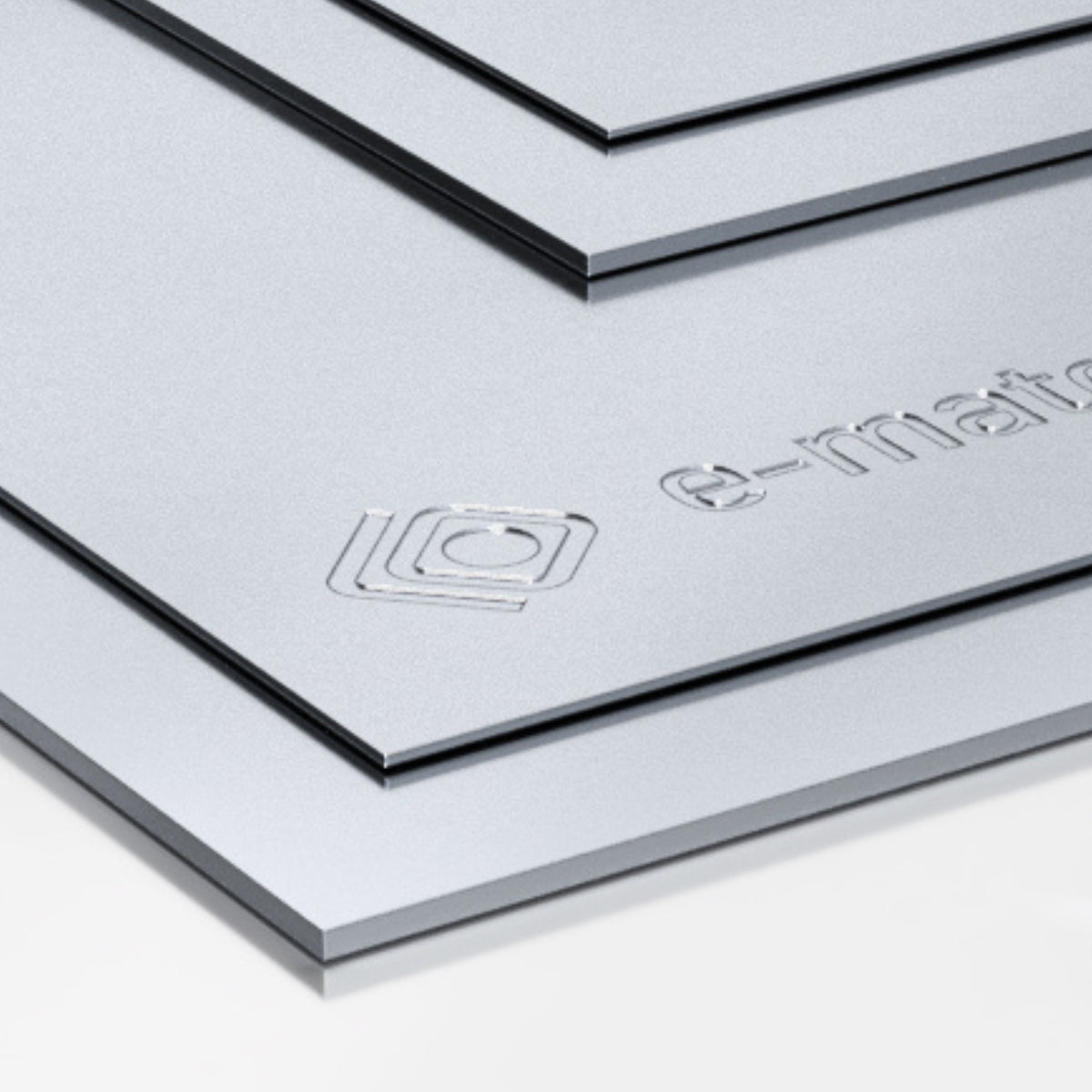 Gładkie blachy aluminiowe ułożone warstwowo o srebrzystej powierzchni i precyzyjnie wyciętych krawędziach z wytłoczonym logo i napisem e-materials na jednej z płyt
