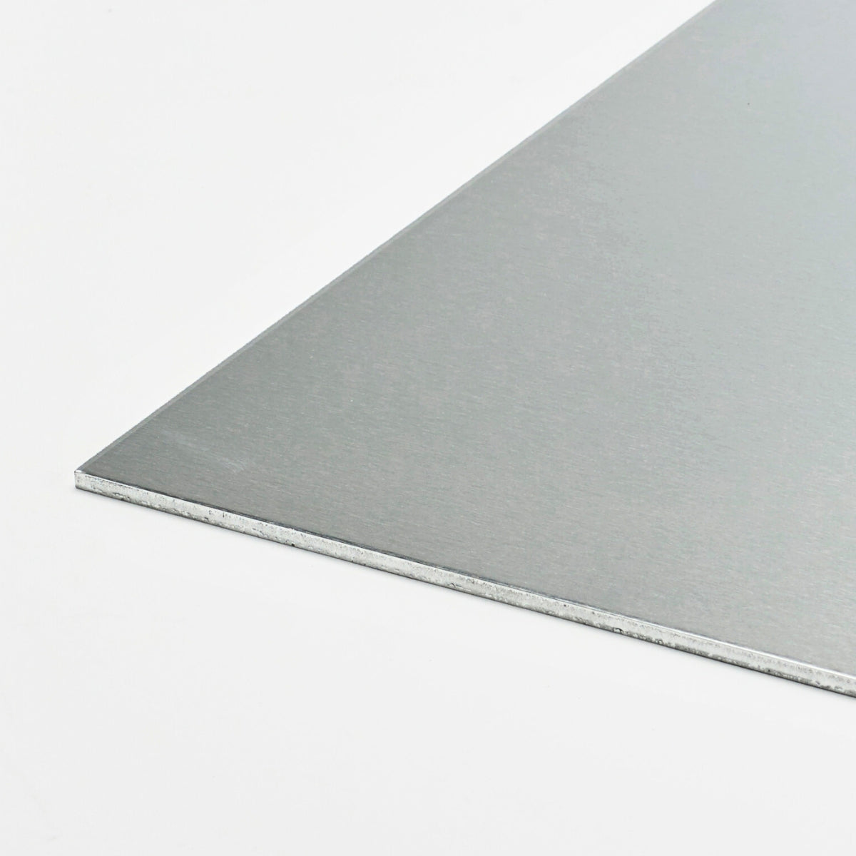 Aluminiowa płyta o gładkiej srebrzystej powierzchni i cienkim przekroju przedstawiona na jasnym tle