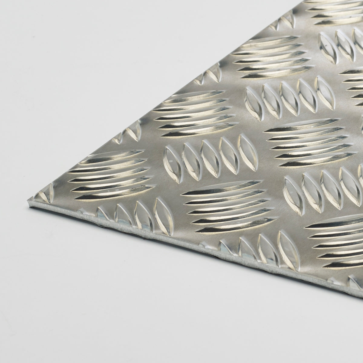 Zbliżenie narożnika aluminiowej blachy ryflowanej z wypukłym wzorem antypoślizgowym