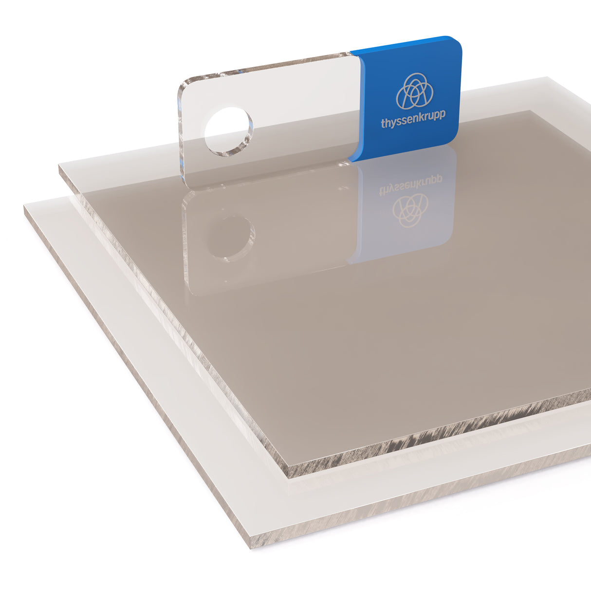 Lita płyta z poliwęglanu (PC) w kolorze dymionym półprzezroczysta o gładkiej i błyszczącej powierzchni ułożona warstwowo na górnej płycie widoczny próbnik z logo thyssenkrupp