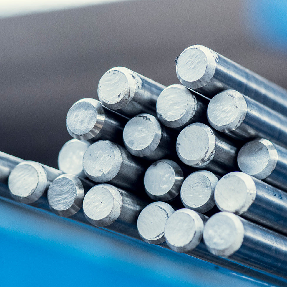 Ułożone równo pręty ze stali nierdzewnej na tle niebieskiej konstrukcji