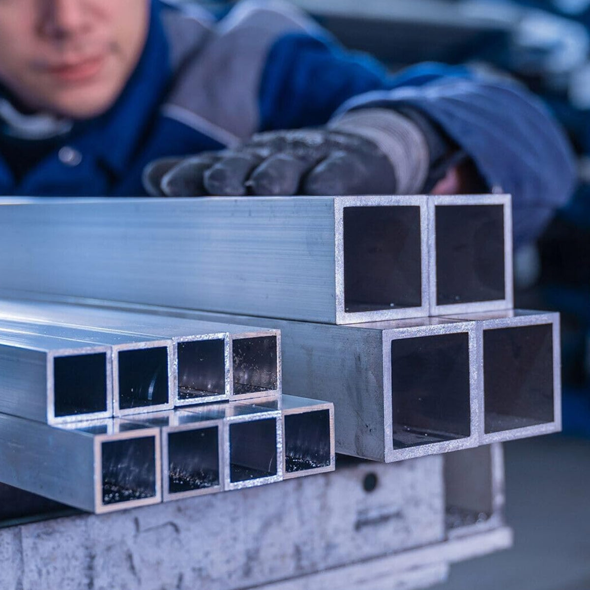 Pracownik w magazynie sprawdzający jakość profili zamkniętych aluminiowych prostokątnych i kwadratowych