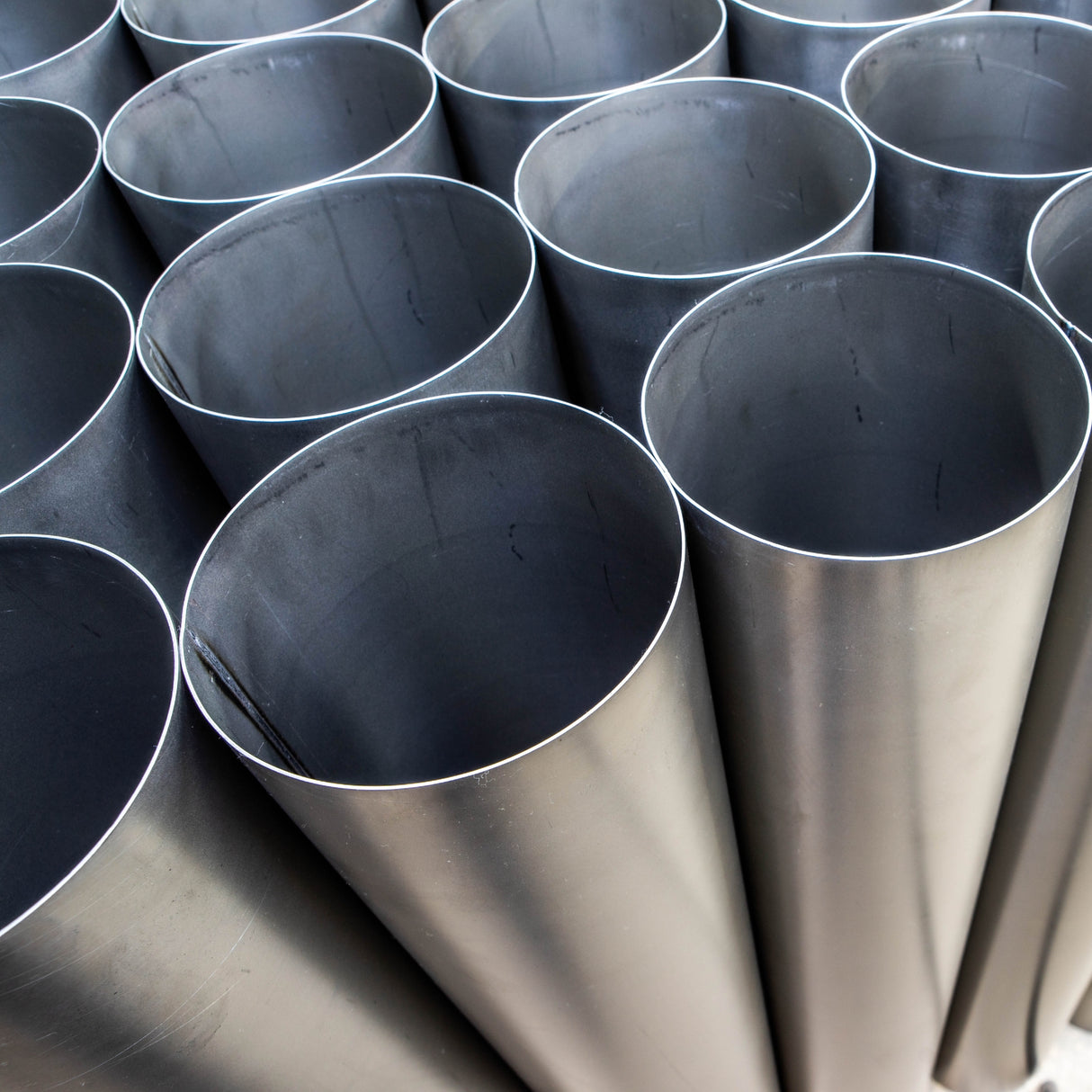 Zbiór dużych cienkościennych rur nierdzewnych ustawionych pionowo widok z góry