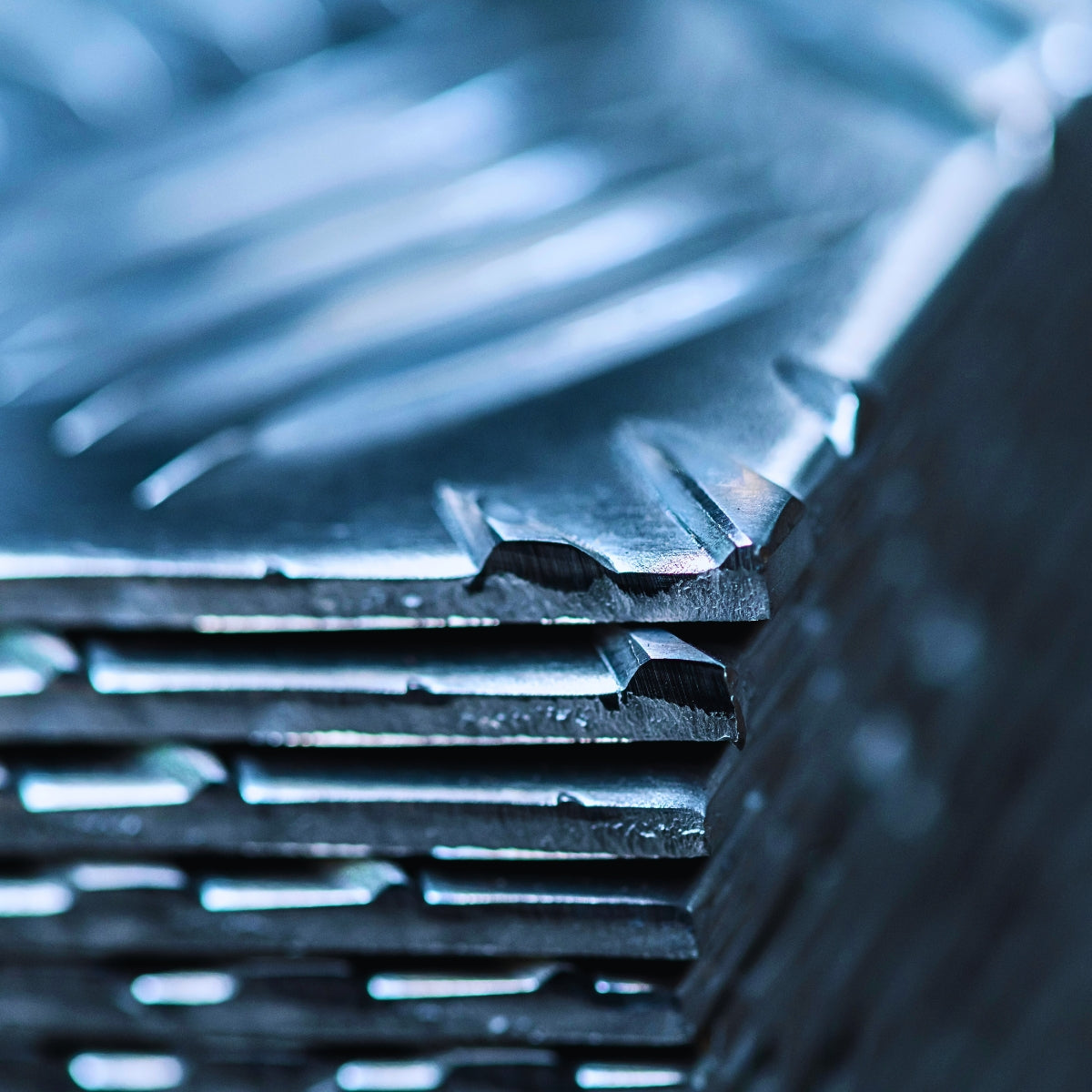 Blachy aluminiowe z ryflowanym wzorem ułożone warstwowo zbliżenie na krawędzie 